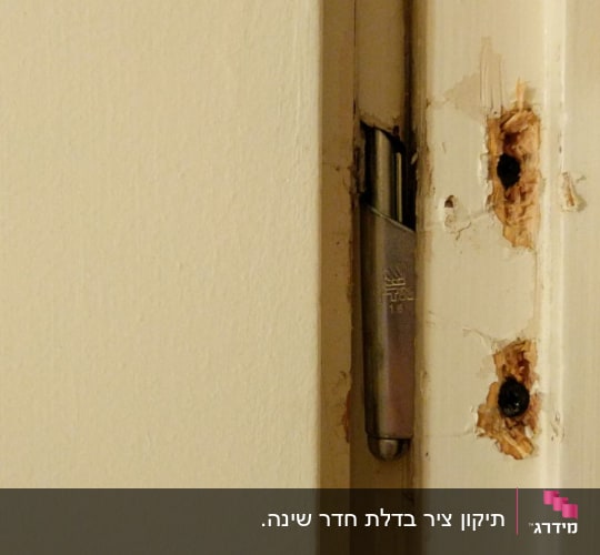 ציר דלת מתכת עם סימני שחיקה בעץ